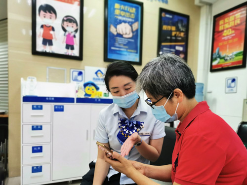 建行成都第六支行，大堂經(jīng)理為客戶介紹手機(jī)銀行“大字”模式